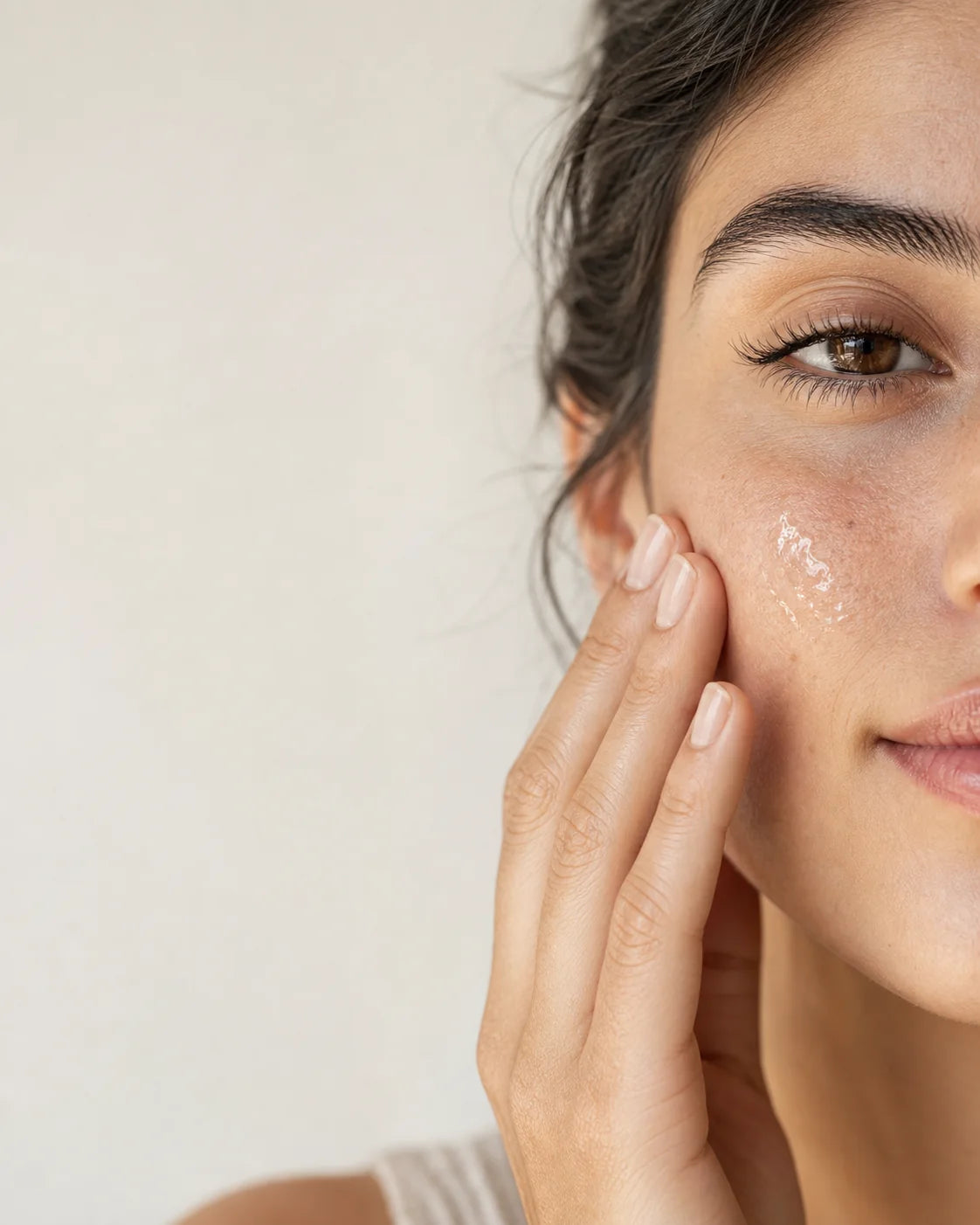 Woman applying Nourishplus serum to her cheek