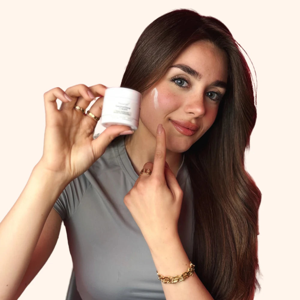 Woman holding the current Nourishplus DermaGlow cream beside a cream swipe